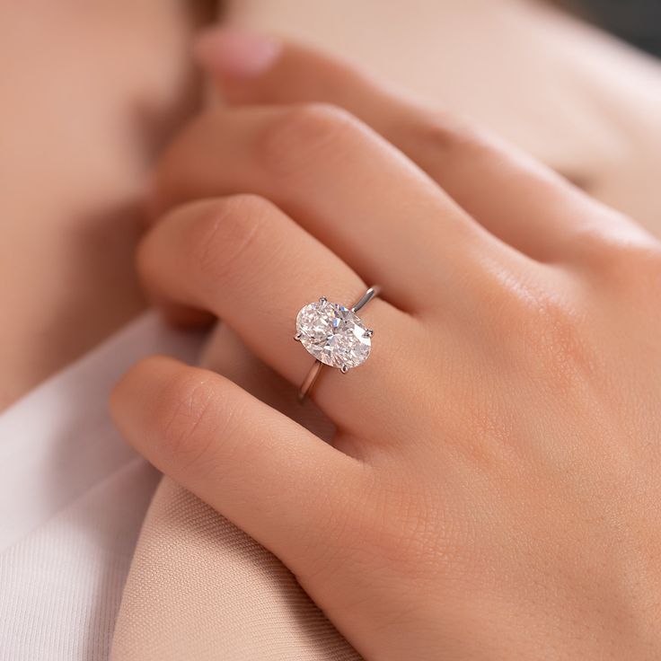 a woman's hand with a diamond ring on her finger