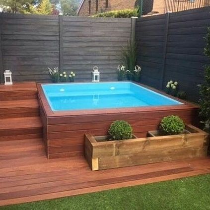 an above ground pool with steps leading up to it and a wooden deck in the middle