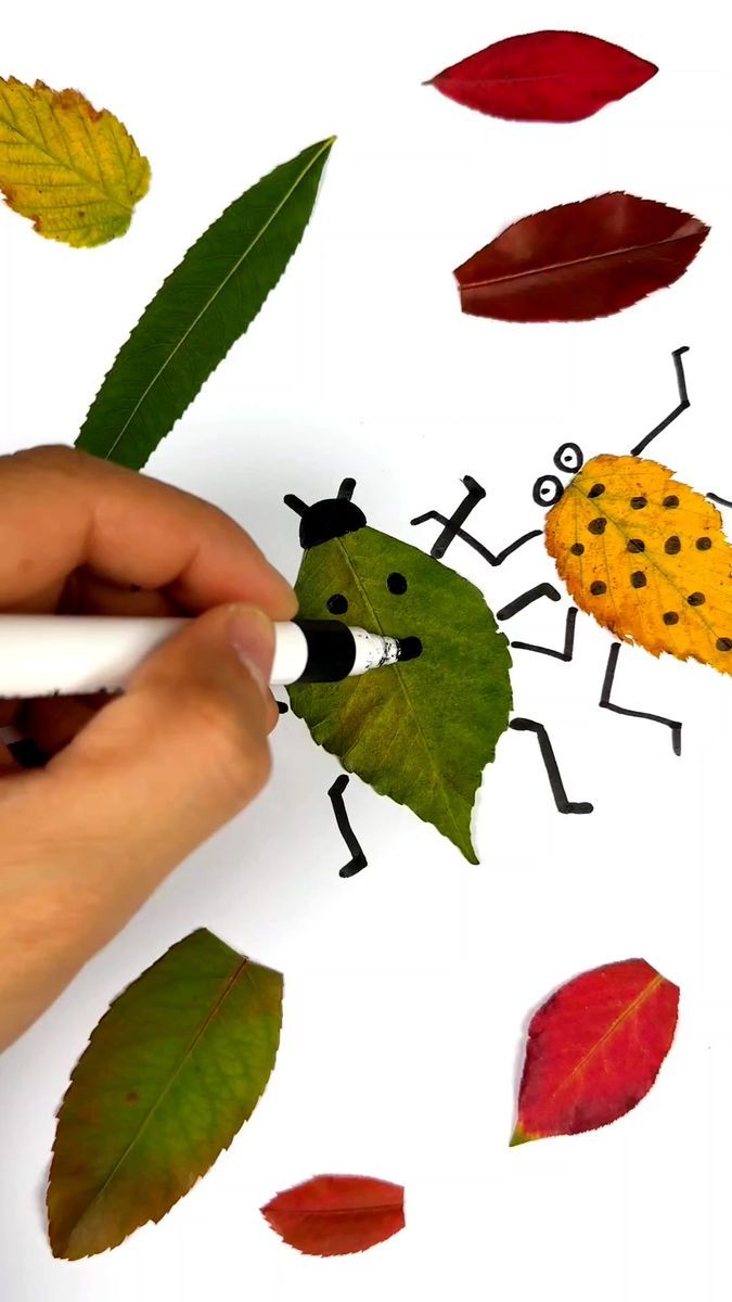 someone is drawing leaves with a marker on the paper and it looks like they are making a ladybug