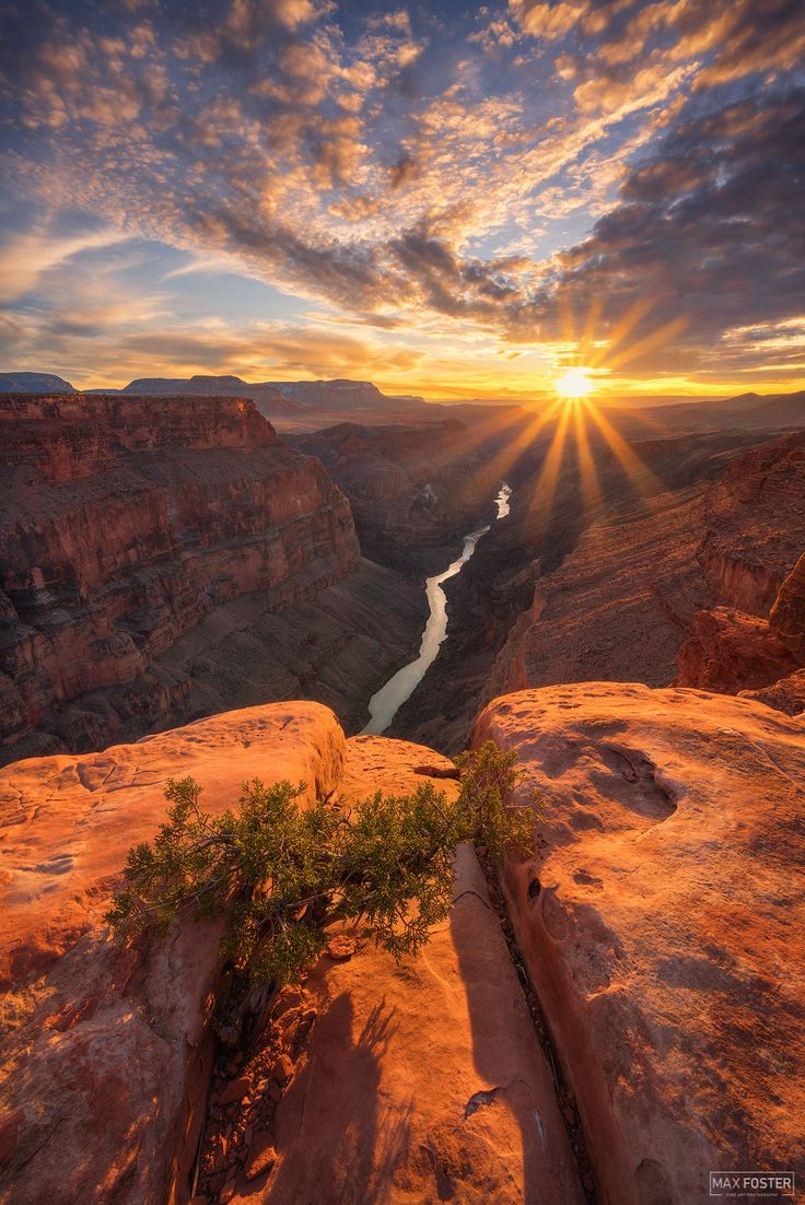 the sun is setting over canyon and river