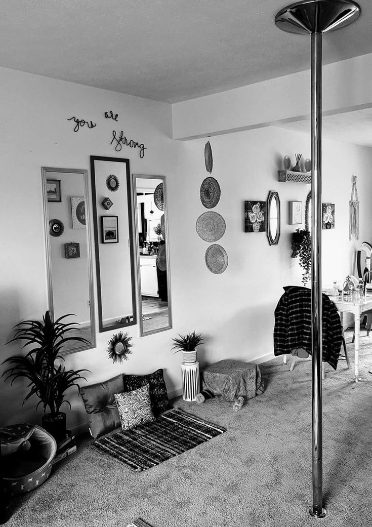 black and white photograph of a living room with mirrors on the wall, couches and rugs