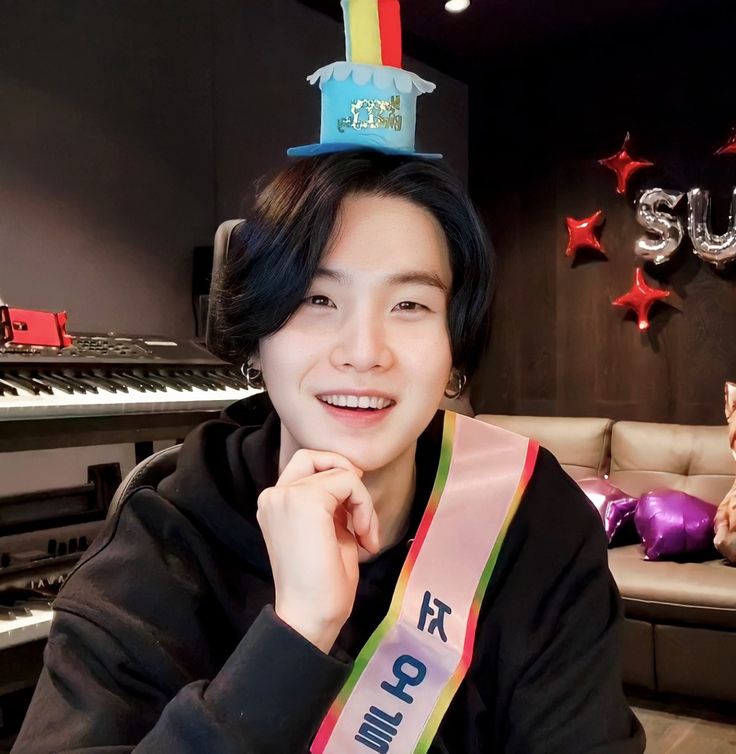 a person sitting in front of a piano with a cake on top of their head