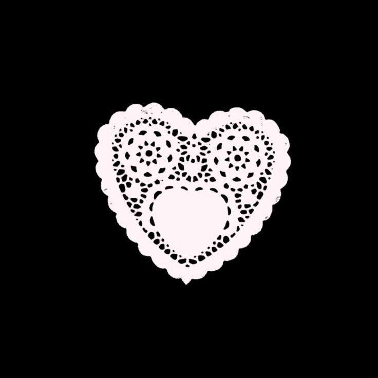 a white doily in the shape of a heart on a black background with dots