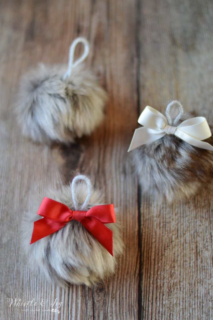 two fuzzy balls with red bows on them