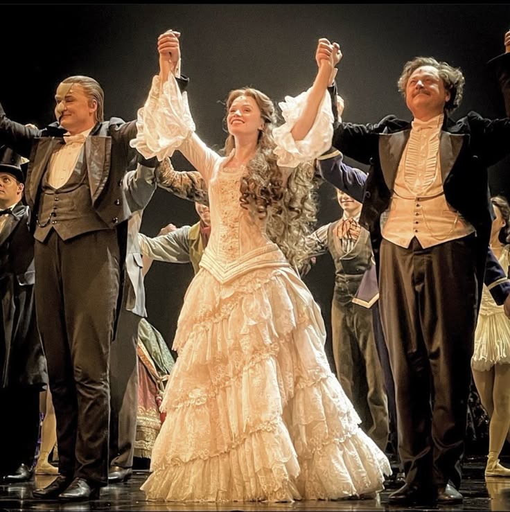 a group of people standing on top of a stage with their arms in the air