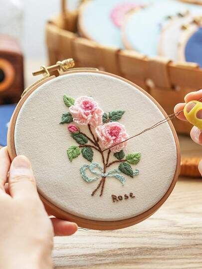 someone is stitching flowers on a small embroidery hoop