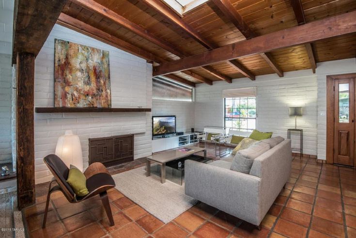 a living room filled with furniture and a flat screen tv on top of a fireplace