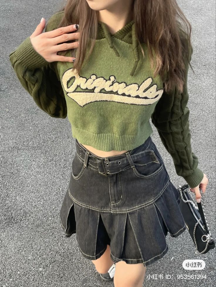 a young woman wearing a green sweater and black skirt with the word grandma written on it