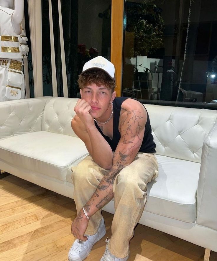 a young man sitting on top of a white couch