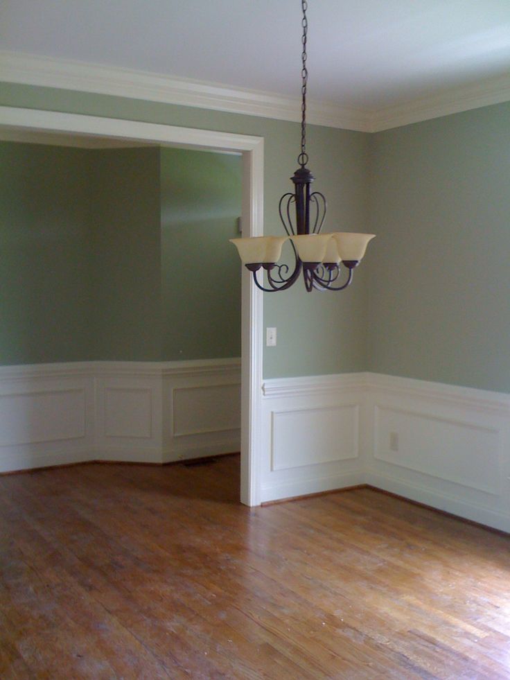 a chandelier hangs from the ceiling in an empty room with hard wood floors