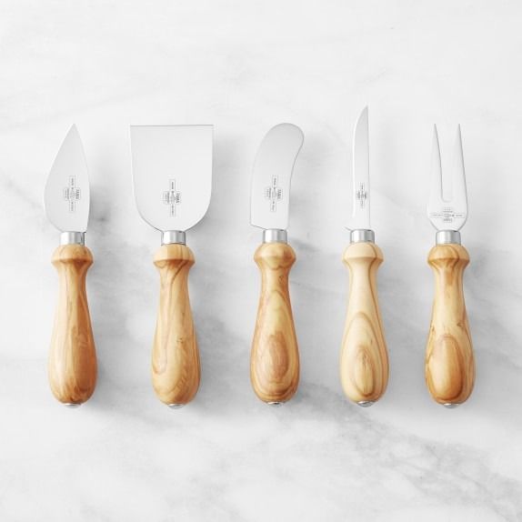 five knives lined up in a row on top of a marble countertop next to each other