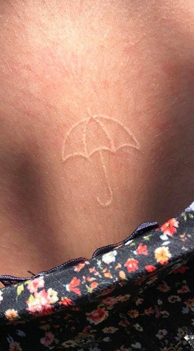 a woman with an umbrella tattoo on her back