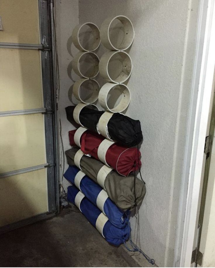 there are many cups and pans stacked on the wall next to an open garage door