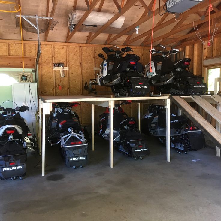 several snowmobiles are lined up in a garage