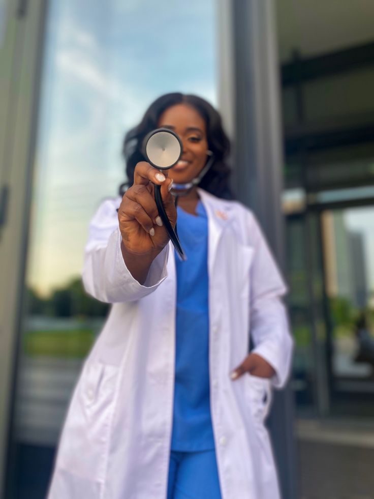 a woman wearing a white lab coat holding a magnifying glass in front of a building