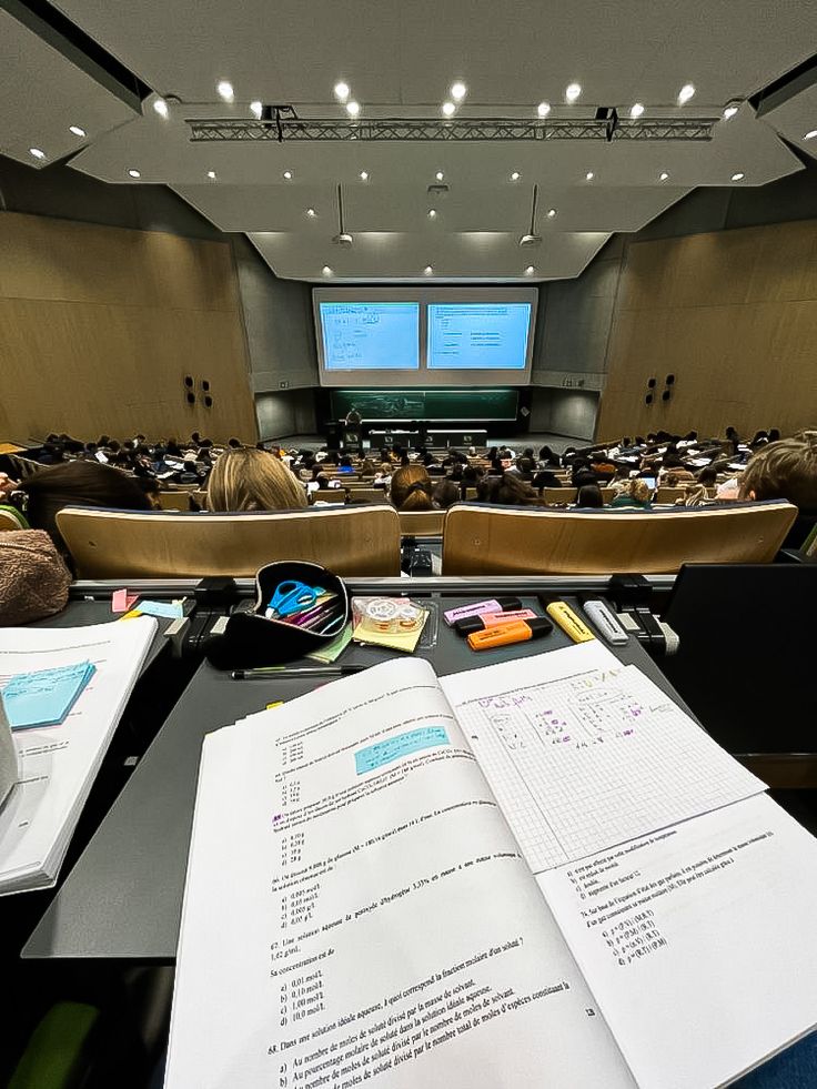 a room full of people sitting at desks in front of a projector screen