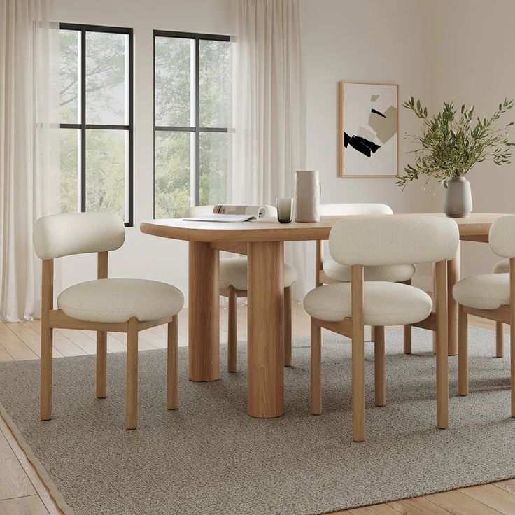 a dining table with four chairs and a potted plant in the corner next to it