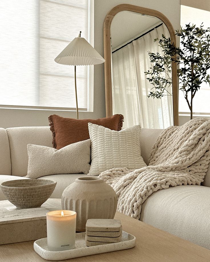 a living room filled with furniture and a candle on top of a wooden coffee table