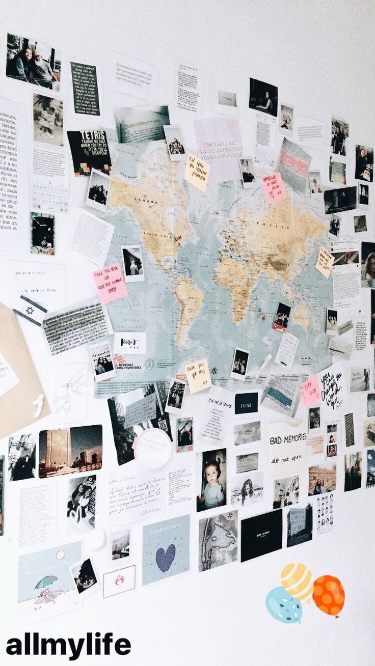 a world map is covered with many photos and magnets on the wall in front of it