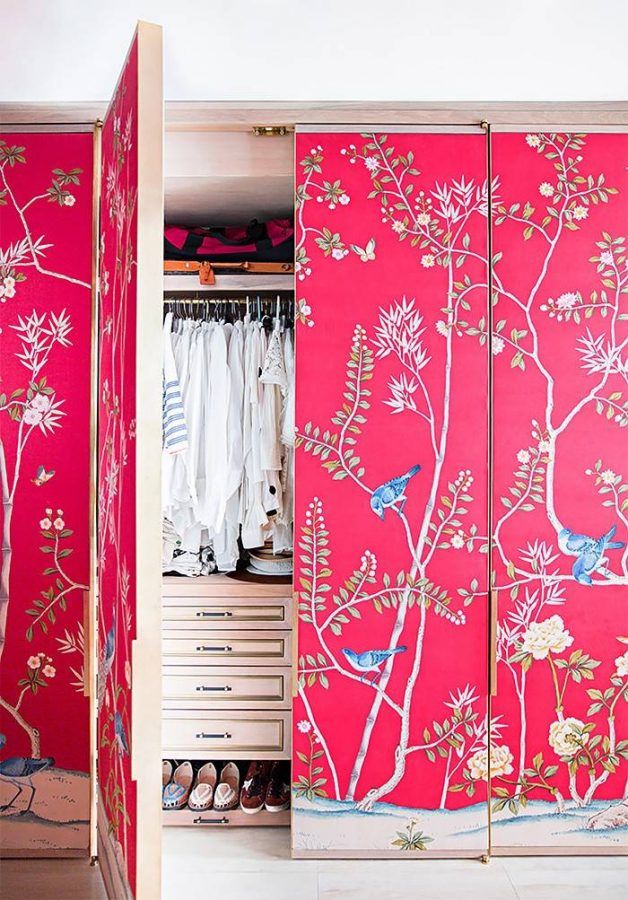 the closet is decorated with pink and white flowers, birds and branches on red fabric