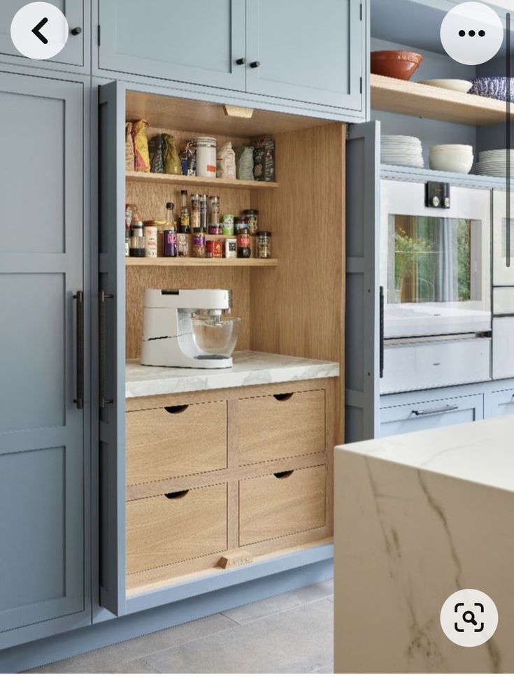 an open cabinet in a kitchen with lots of cupboard space and drawers on the side