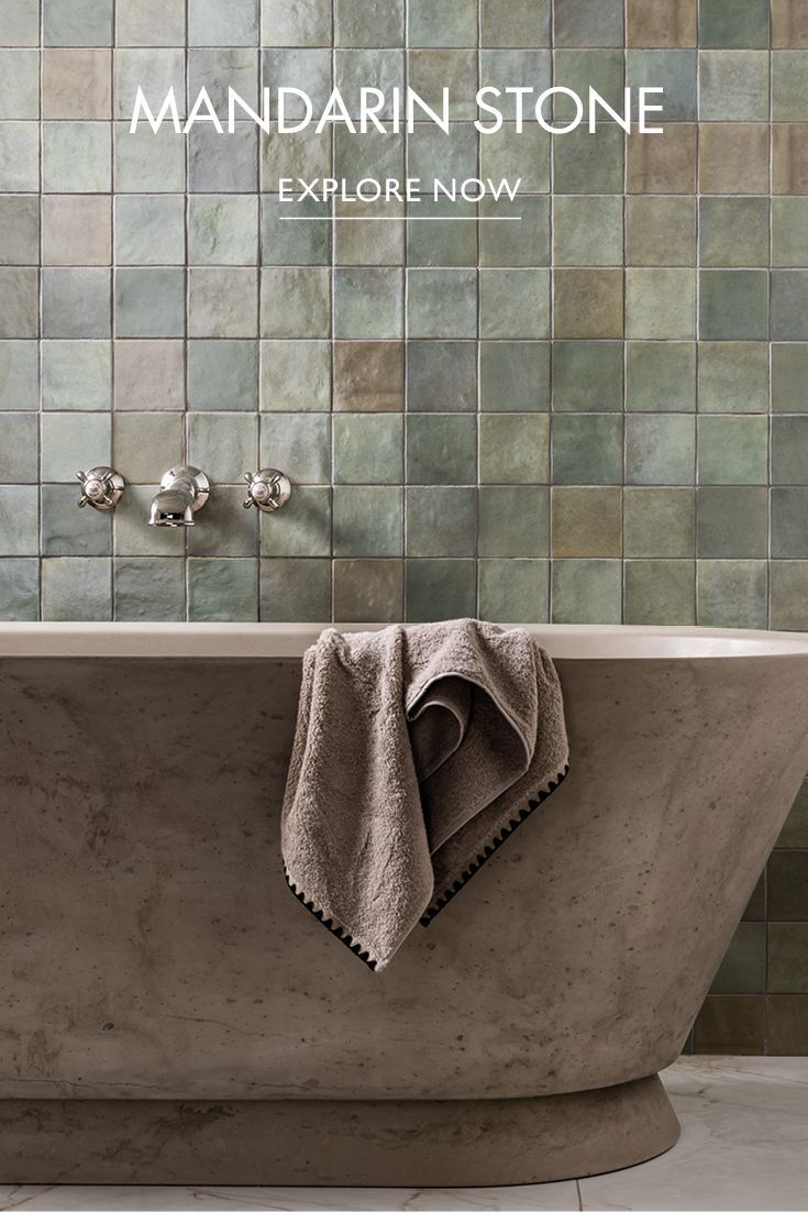 a stone bathtub in front of a tiled wall with the words mandarin stone explore now