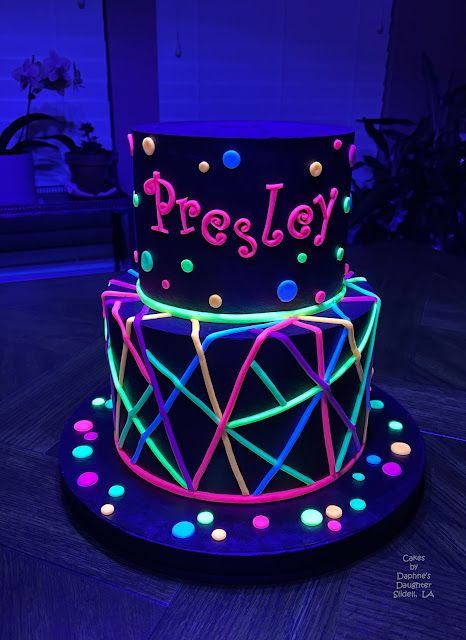 a lit up cake with the word presley on it's side and colorful lights around it