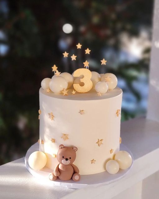 a birthday cake decorated with stars and a teddy bear