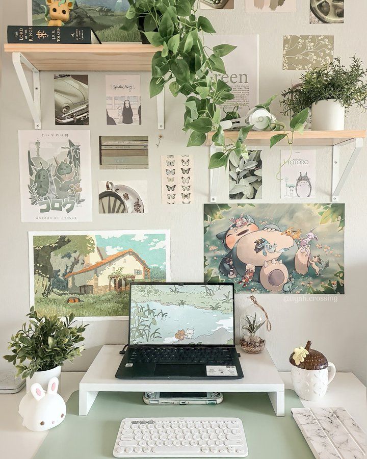 a laptop computer sitting on top of a desk next to a keyboard and mouse in front of a wall covered with pictures