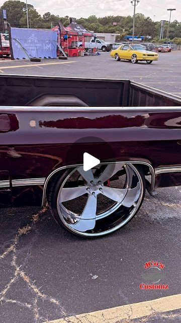 a purple car with chrome rims parked in a parking lot