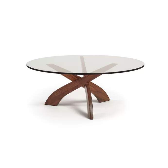 an oval glass table with wooden legs