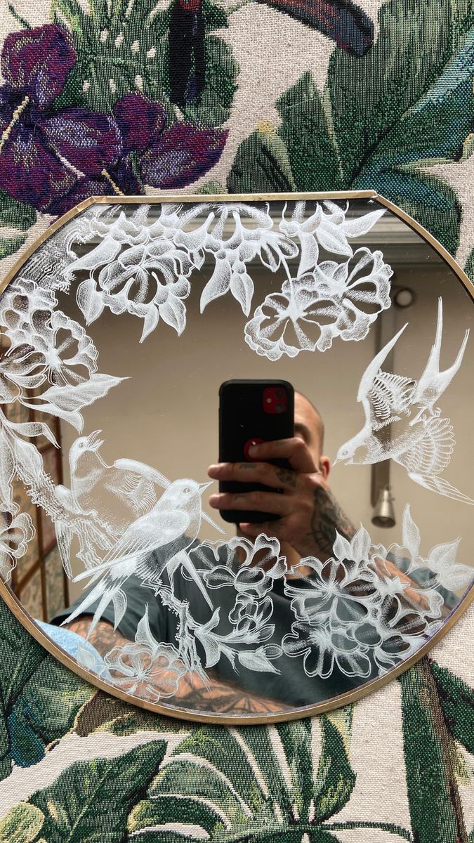 a person taking a selfie in front of a mirror with white flowers on it