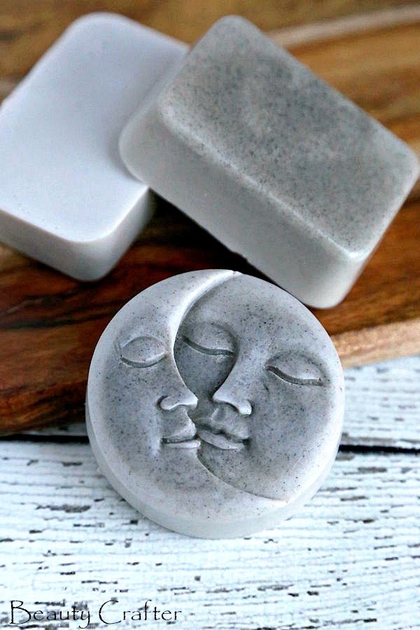 two soap bars sitting on top of a wooden cutting board next to a white mold