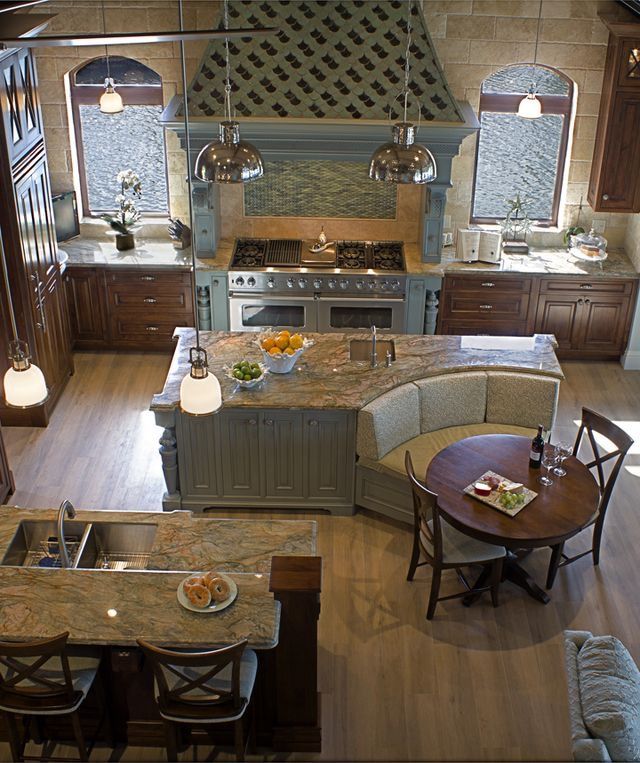 an aerial view of a kitchen and dining room area with wood flooring, granite counter tops, cabinets, and appliances