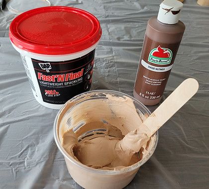 there is a cup of ice cream next to a container of chocolate frosting and a plastic spoon