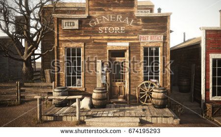 an old western store with barrels outside