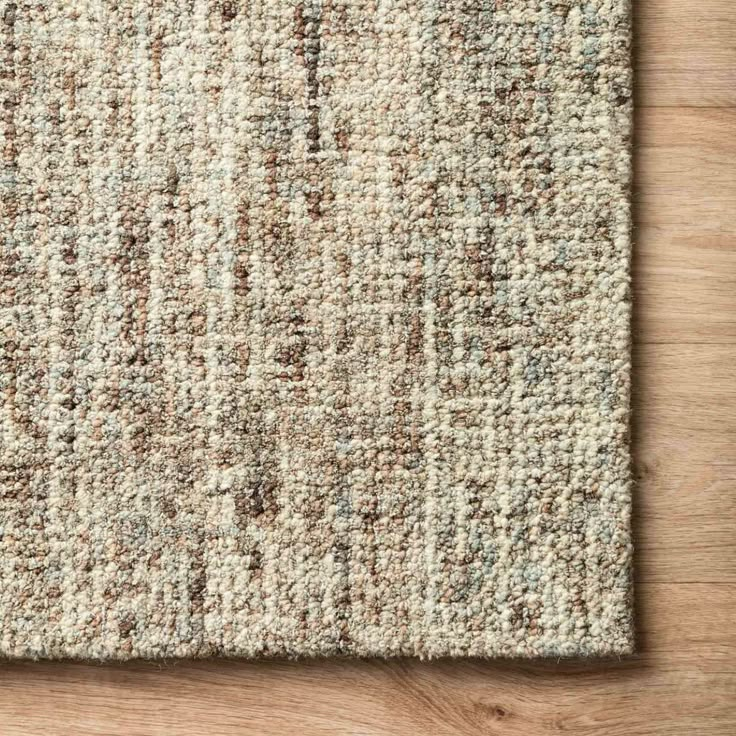 an area rug on top of a wooden floor with a white and brown color scheme