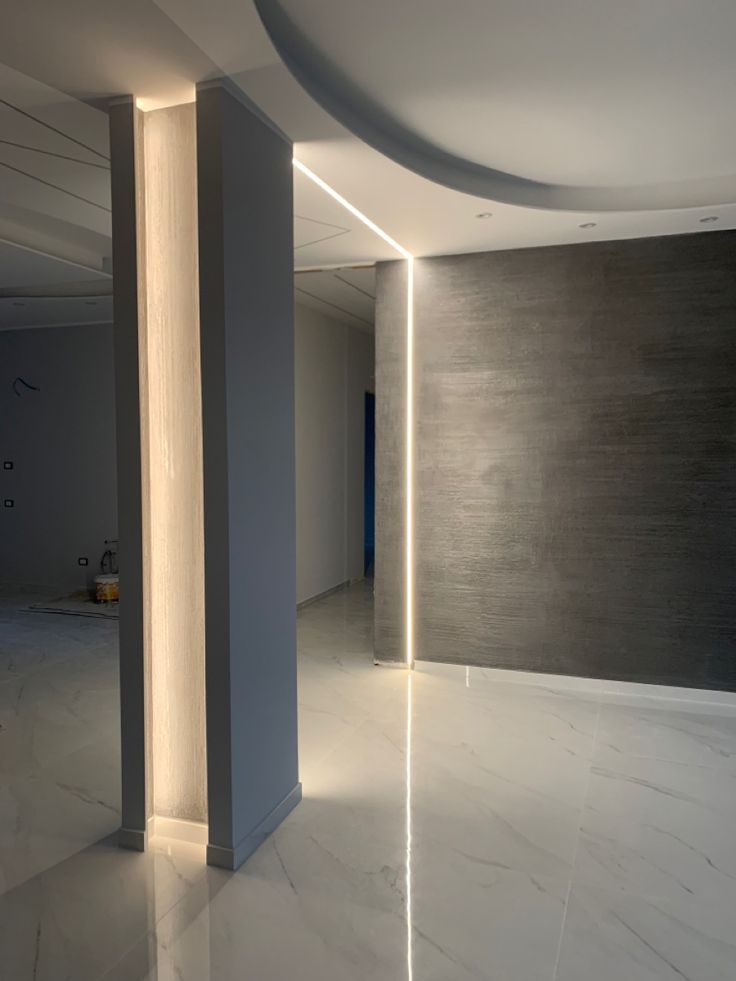 an empty room with columns and lights on the wall, in white marble flooring