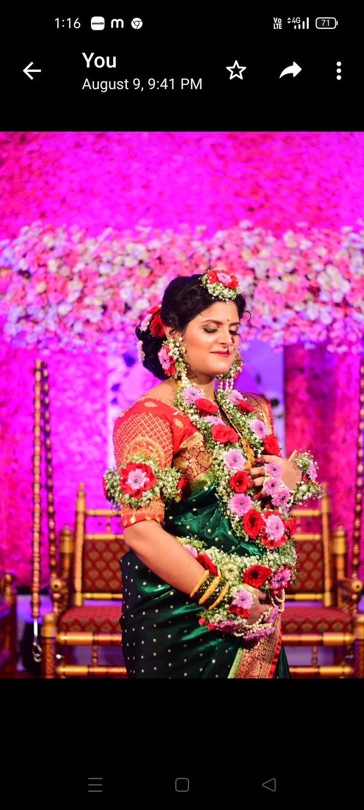 a woman standing in front of a stage with flowers on it