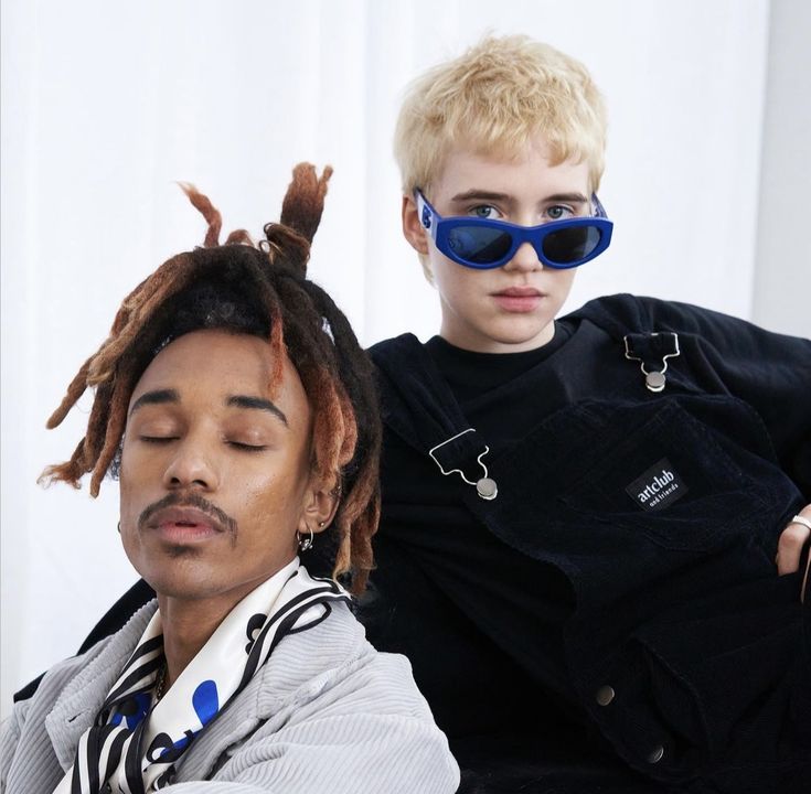 two young men sitting next to each other with their eyes covered by fake hair and sunglasses