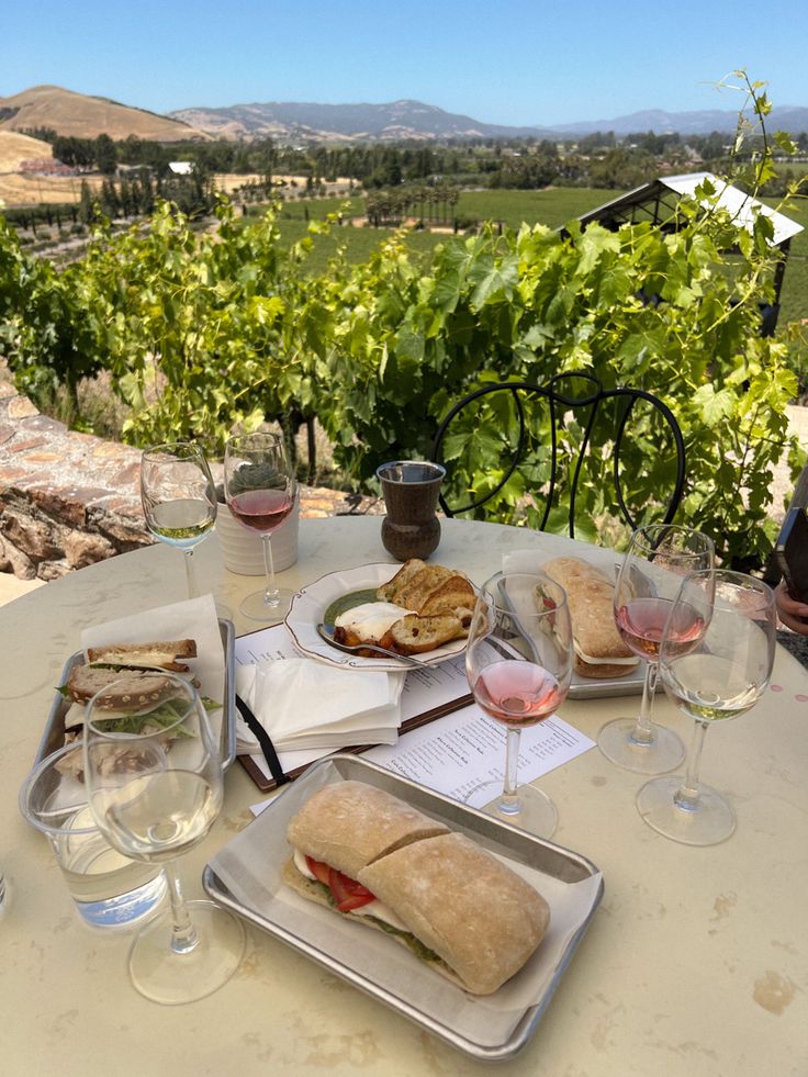 a table with wine glasses and sandwiches on it