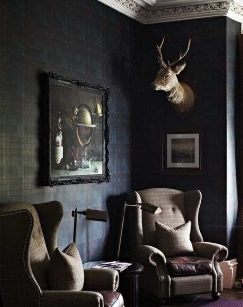 a living room filled with furniture and a deer head mounted to the wall