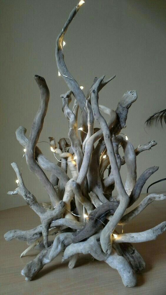 a sculpture made out of driftwood with lights on it