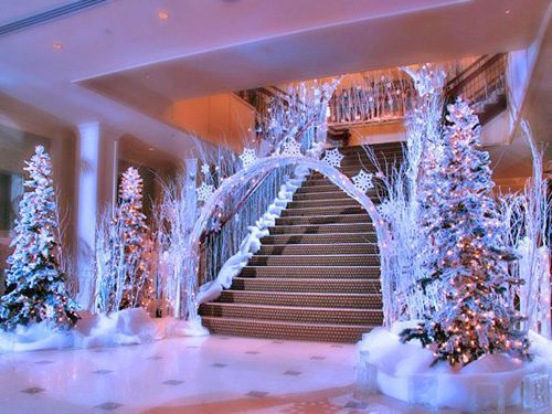 the lobby is decorated for christmas with white trees and snow - covered decorations on display