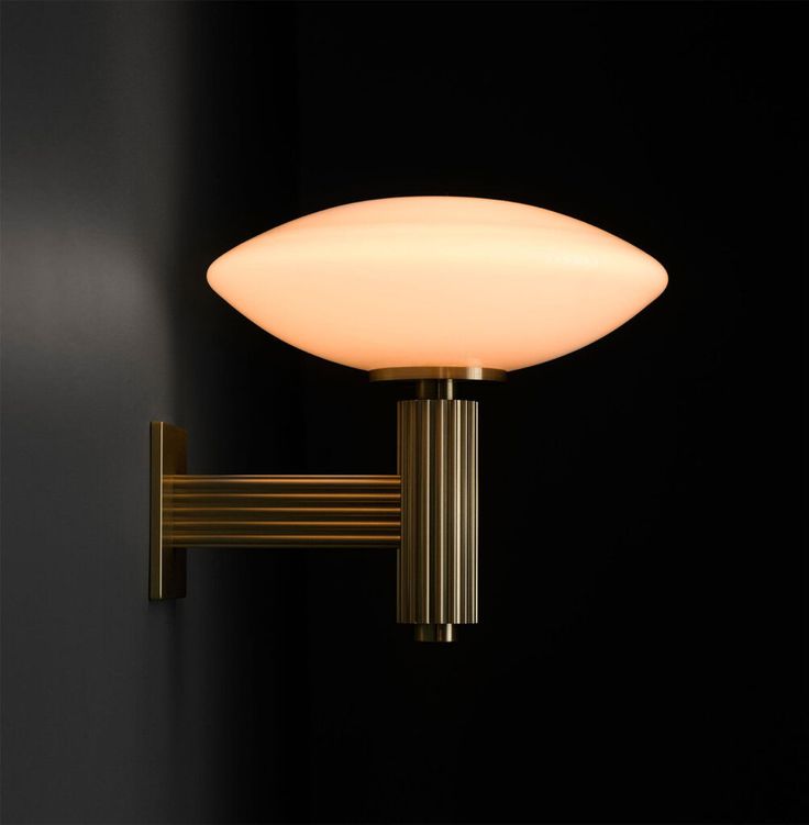 a wall light that is on the side of a wall with a black back ground