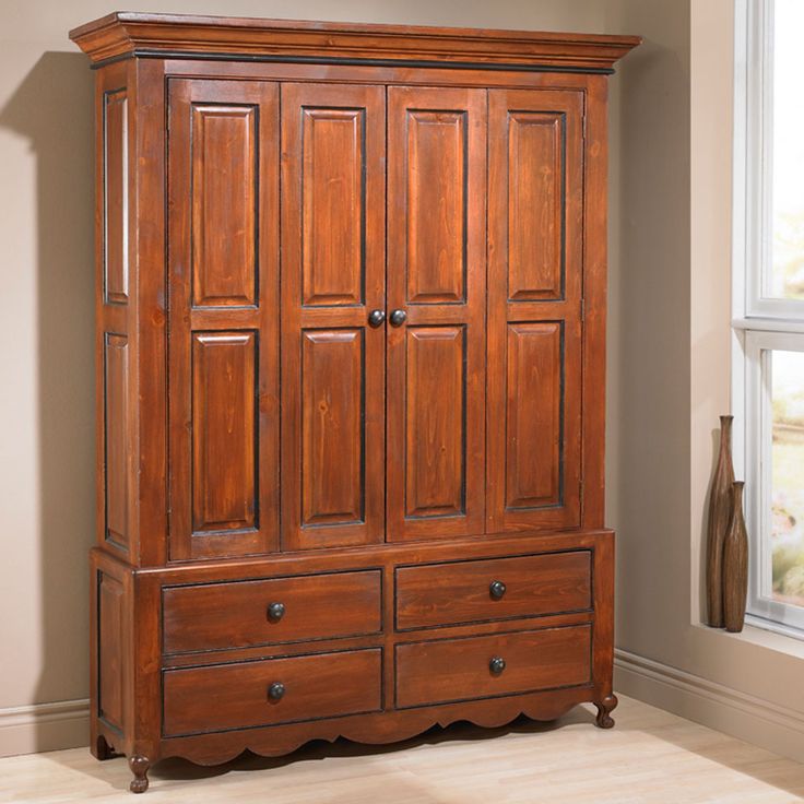 a large wooden armoire with drawers in a room next to a window and vase on the floor