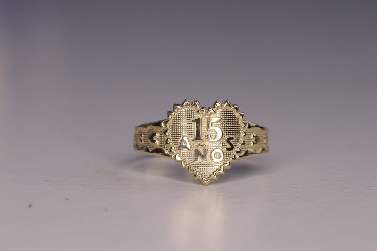 a gold ring with the number fifteen five on it's front and back sides