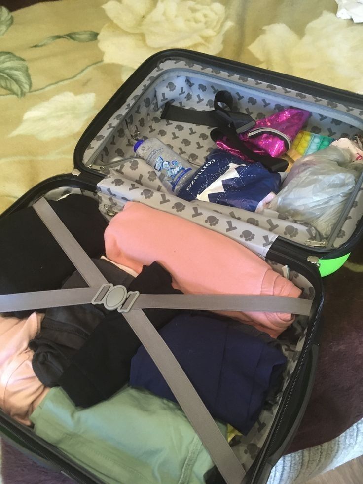 an open suitcase filled with clothes on a bed