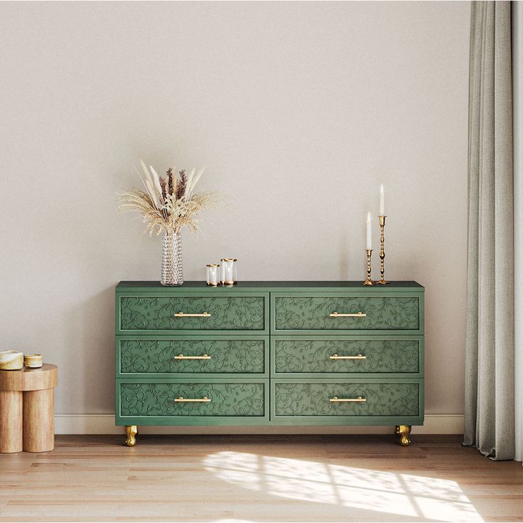 a green dresser sitting next to a window in a living room with white walls and wooden floors