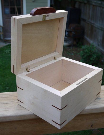 an open wooden box sitting on top of a wooden bench